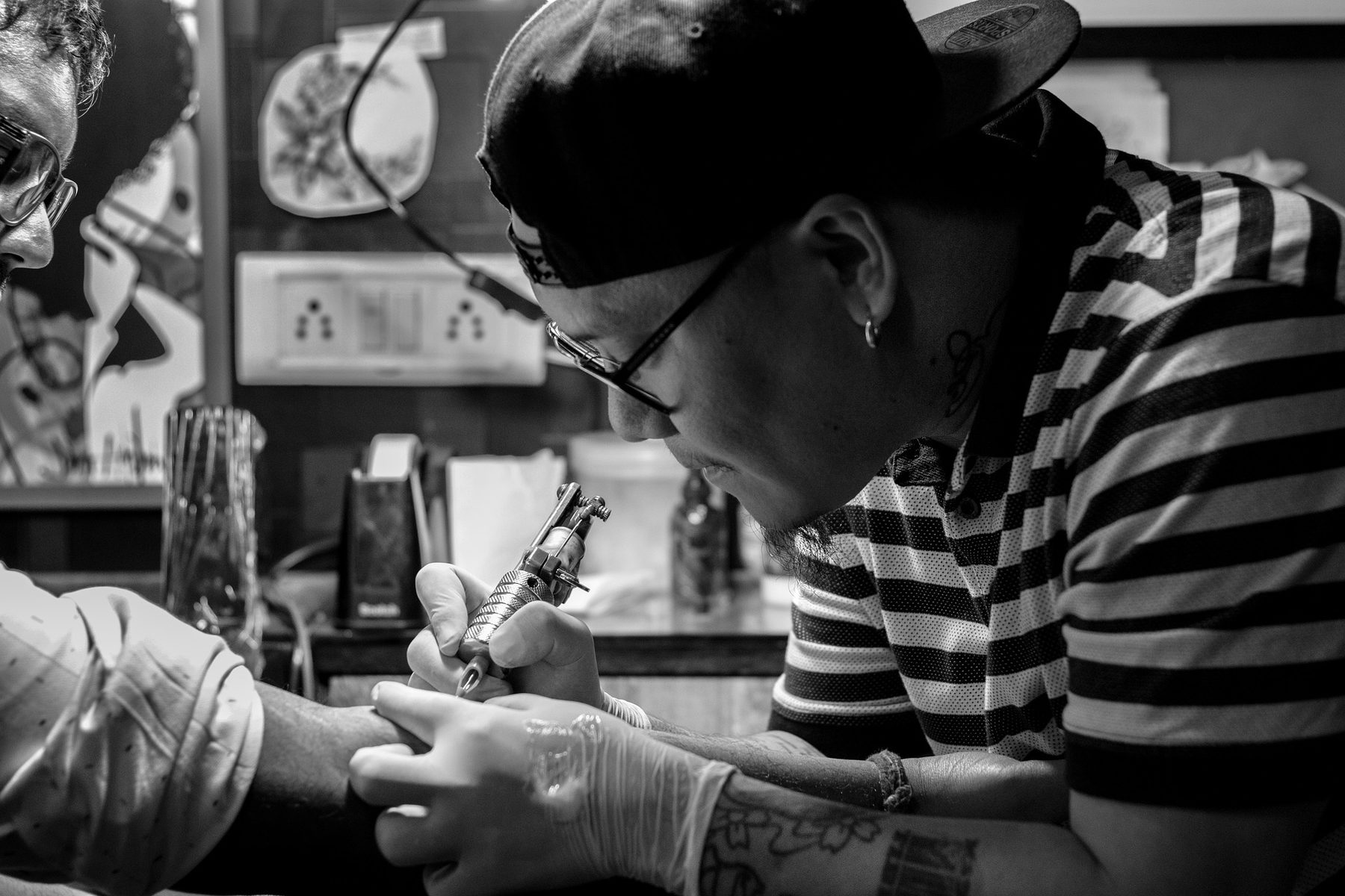 Job Role Image (Tattooist and customer, black and white)